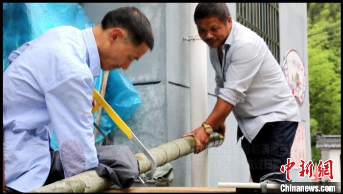 王金胜在村民帮助下锯毛竹 衢江区委宣传部提供 摄