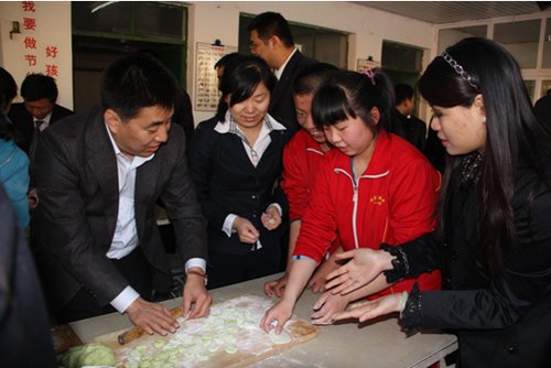 华电瑞通公司迟景涛董事长(左一)、腾讯公益基金会王齐秘书长(右一)和孩子们一起包饺子