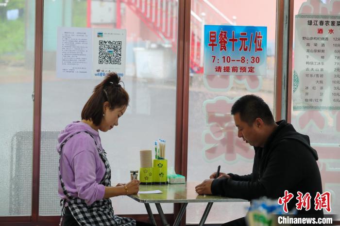 图为黄树鹏(右一)与妻子在交流工作。　于海洋 摄